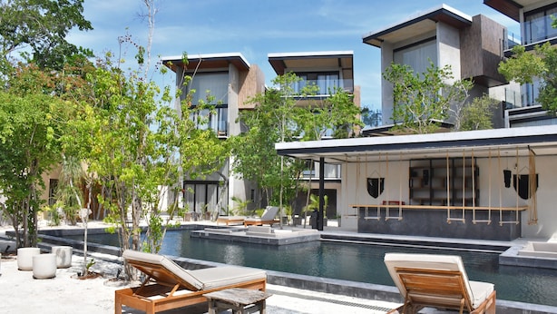 A modern resort with a pool area, lounge chairs, and a view of the surrounding buildings. - Nook Tulum by The Spot Rentals (Tulum)