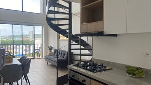 Una cocina moderna con una escalera de caracol, un comedor con vistas y un balcón con vista a la ciudad.