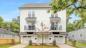 A two-story residential building with a symmetrical facade, a central entrance, and a small front yard with a tree. - Hot Tub • Game Room • Rooftop Fire Pit • Uptown (Charlotte)