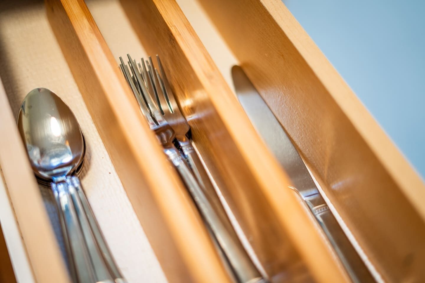 A drawer with a spoon, forks, and a knife.