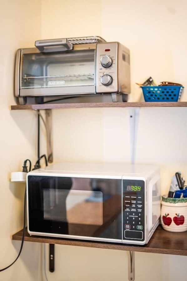 Una cocina con un tostador y un microondas en un estante.