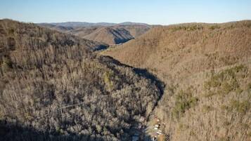 A winding road through a mountainous area with sparse vegetation and a clear blue sky.