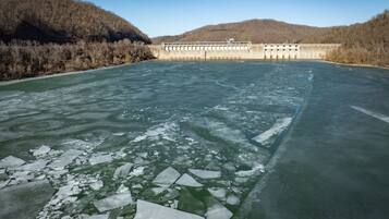 A frozen river with a dam in the background.