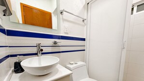 Un baño con lavamanos, inodoro y ducha blancos.