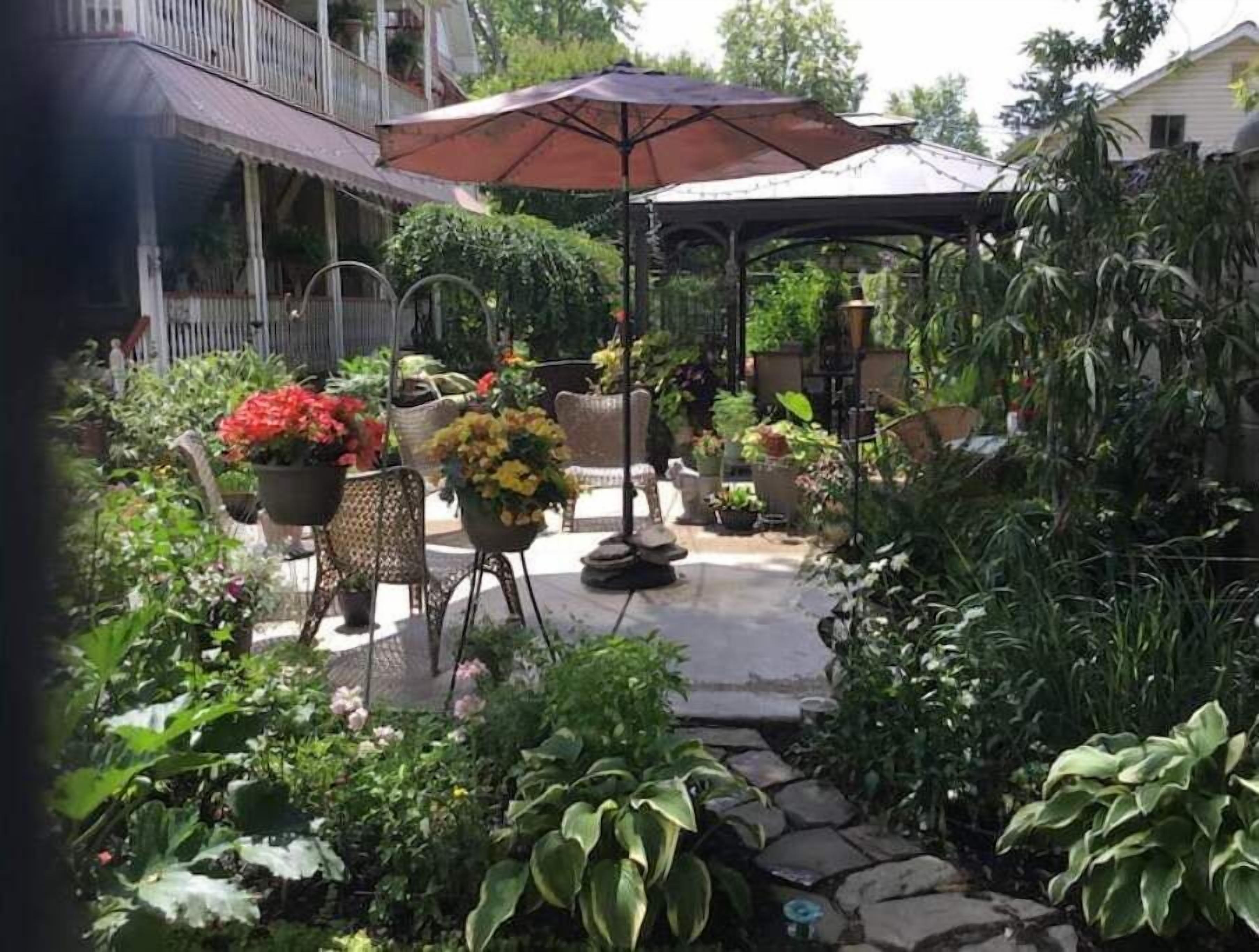 A covered patio area with outdoor seating and potted plants.