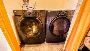 A compact laundry room with two front-loading washing machines and a dryer.