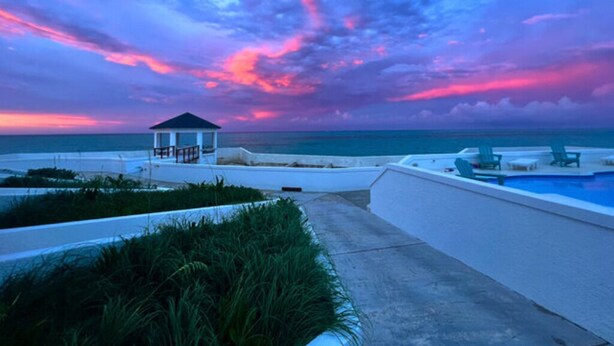 A rooftop pool area with a gazebo, lounge chairs, and a view of the ocean at sunset. - Sea La Vie - Schooner's Landing (Man-O-War Cay)