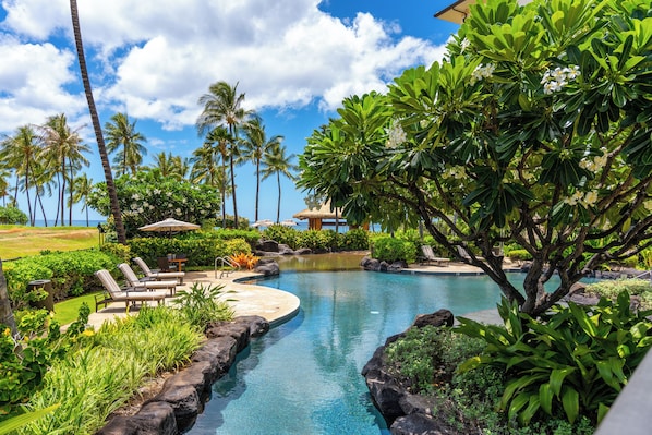 A garden pool that opens toward the palms and the ocean past them.