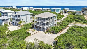 A coastal residential area with multiple two-story houses, featuring balconies and a view of the ocean.