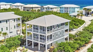 A coastal residential area with multiple two-story houses, featuring balconies and a view of the ocean.