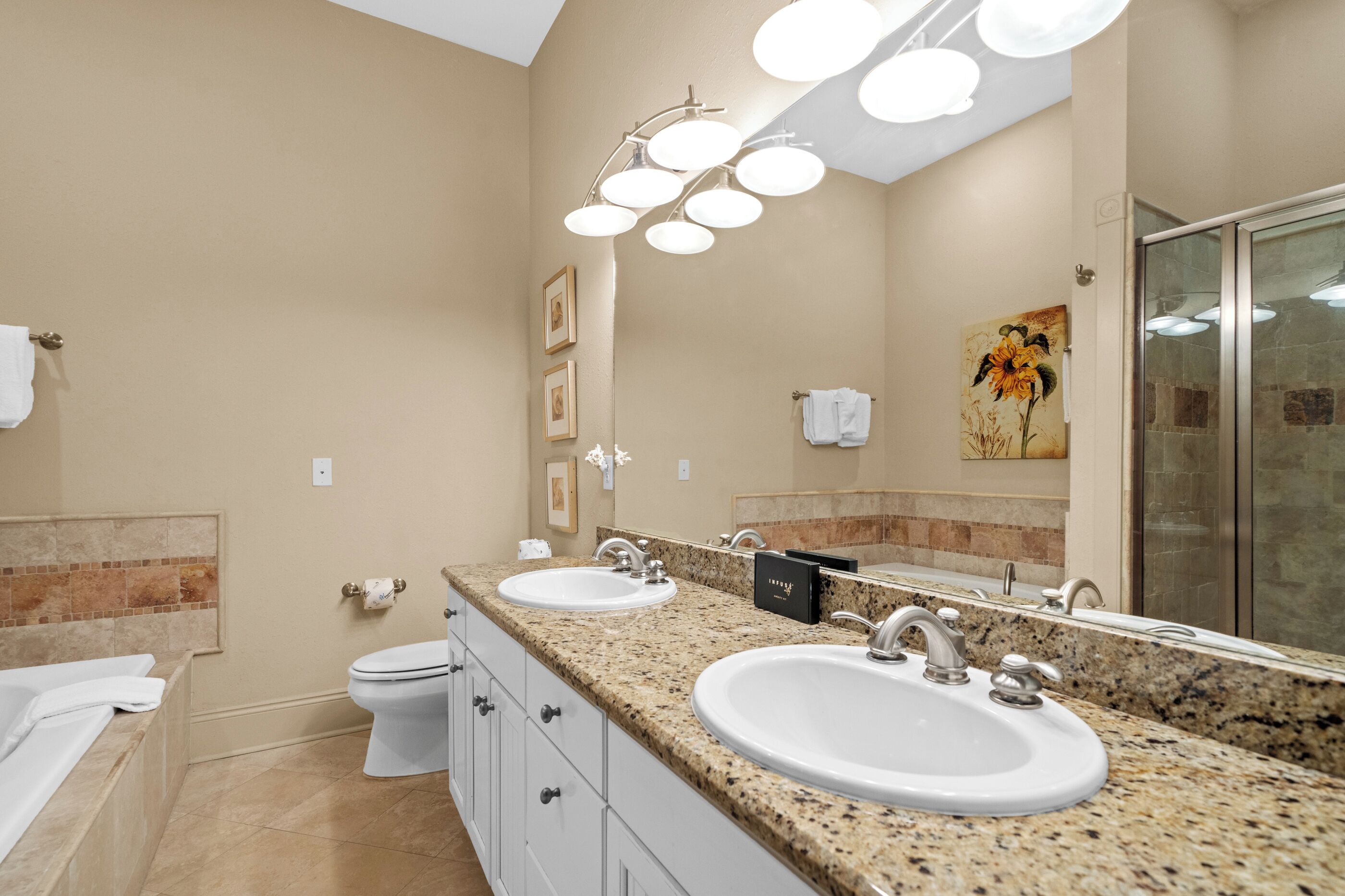 A bathroom with two sinks, a toilet, and a shower.