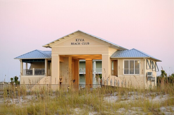 A beach club building with a sign reading 'KIVA BEACH CLUB' and a covered entrance.