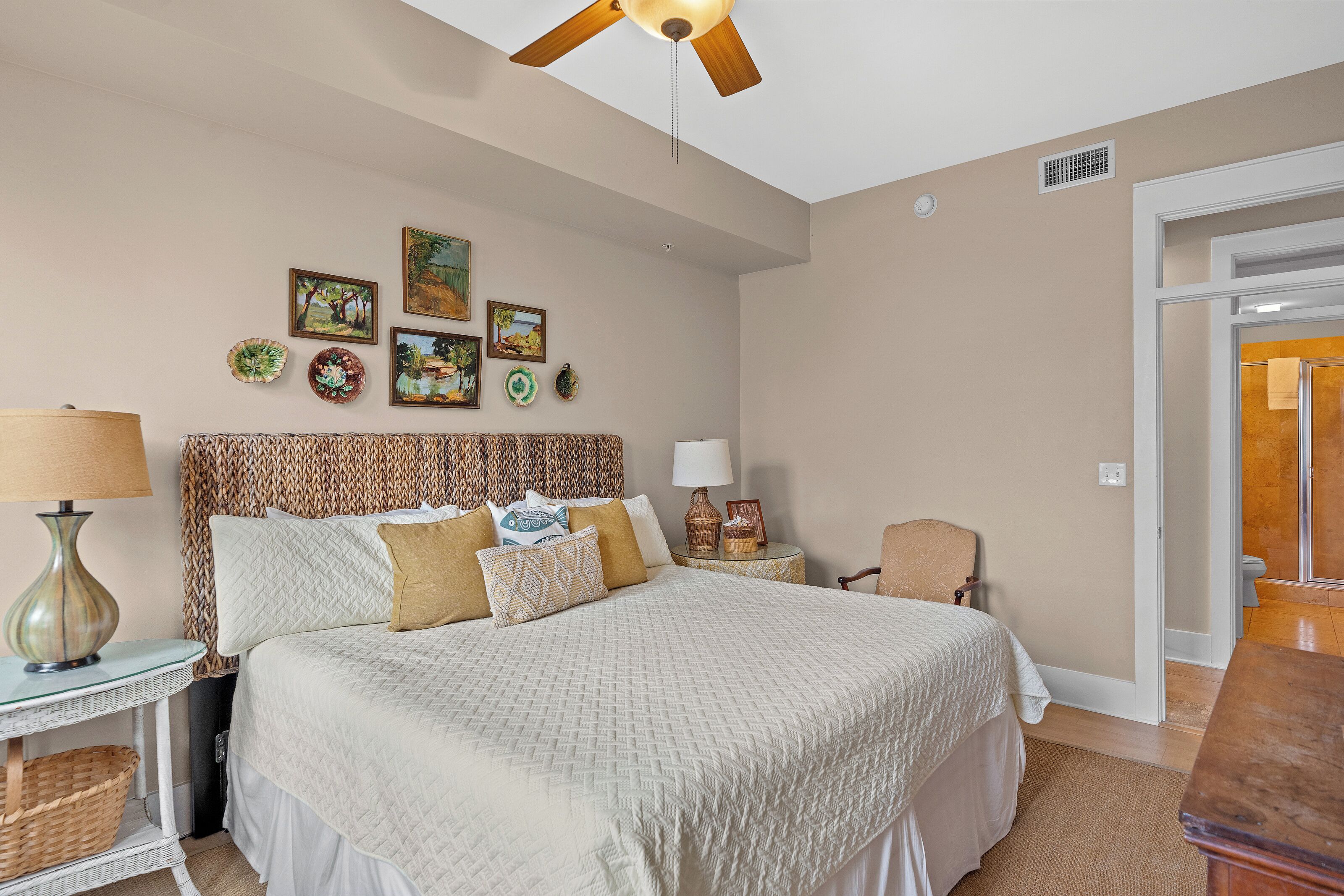 Un dormitorio con cama, mesita de noche, lámpara, silla y decoración en la pared.