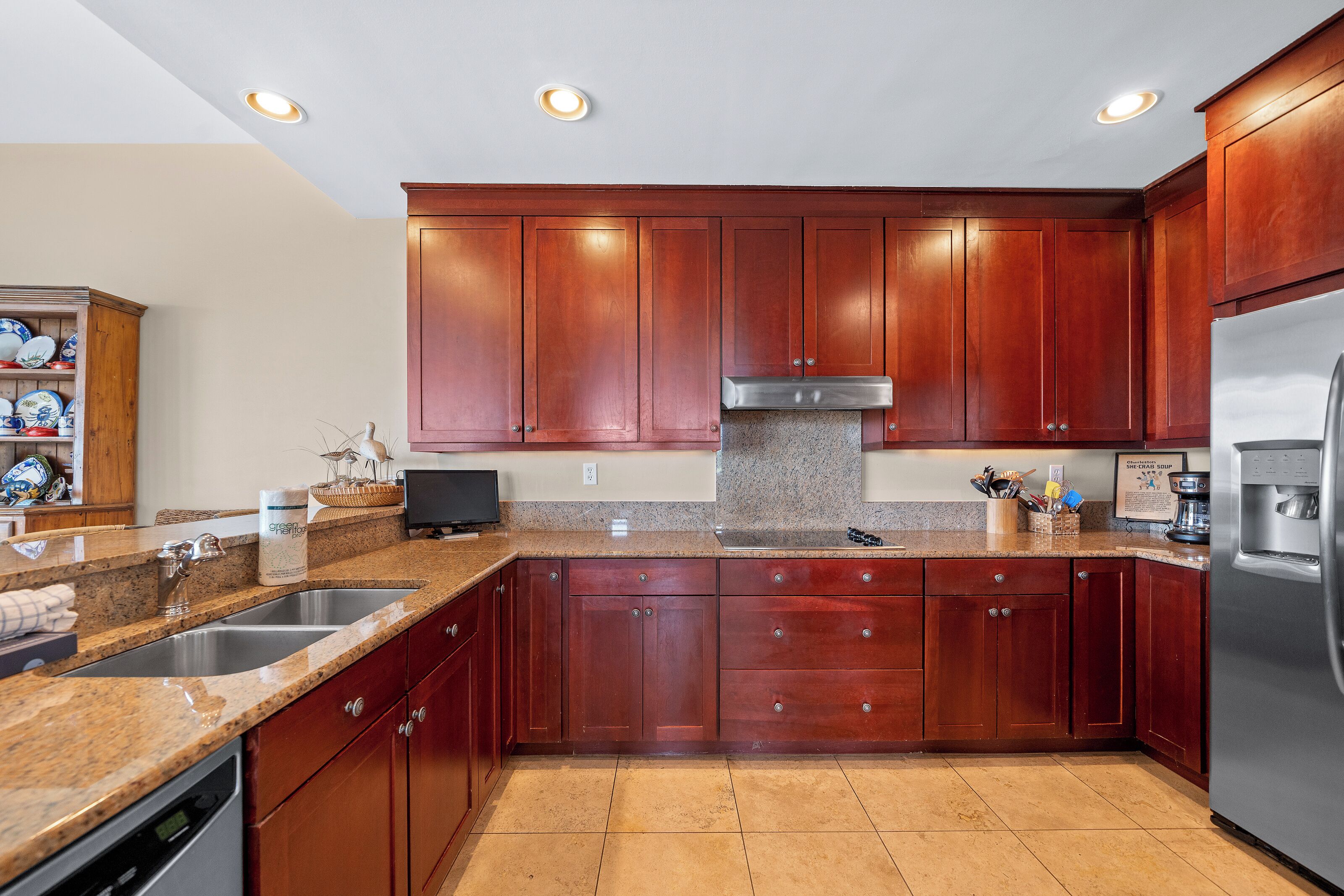 A kitchen with granite countertops, stainless steel appliances, wooden cabinets, and a built-in oven.