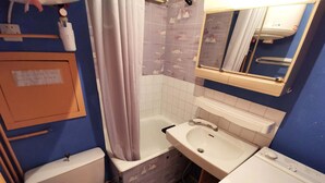 Ein Badezimmer mit Toilette, Badewanne, Waschbecken und Spiegel.