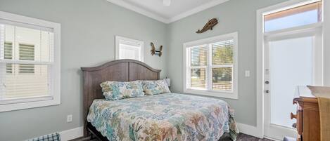 Un dormitorio con una cama, ventilador de techo y una ventana con persianas.