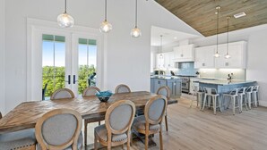 A modern kitchen with white cabinets, a central island, and pendant lighting.