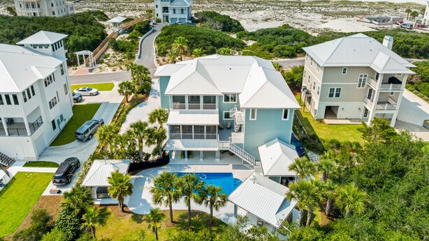 A coastal property with multiple buildings, a swimming pool, and a beach view.
