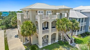 Un edificio de varios pisos con balcones, un porche cubierto y palmeras.