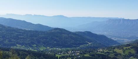 A panoramic view of a mountainous landscape with a valley below, featuring a small town nestled among the hills.