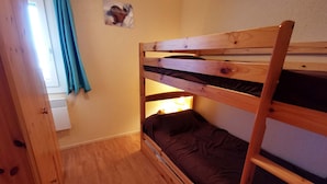 A bunk bed room with a wooden ladder, a small window with curtains, and a wall-mounted picture. - 2-Room Apt at the Foot of the Slopes, Sleeps 5 (Les Adrets-Prapoutel)