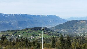A mountainous landscape with a small village and a wind turbine.