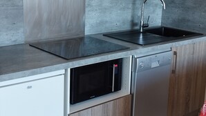 A modern kitchen with a stainless steel sink, a built-in oven, and a dishwasher.