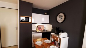 A compact kitchen with a microwave, sink, and coffee maker.