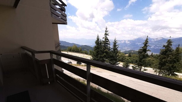 A balcony with a view of a mountain range and trees. - Apartment in Adrets-Prapoutel, 2 rooms, balcony, close to slopes and shops (Les Adrets-Prapoutel)