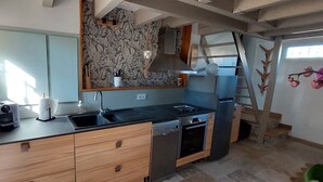 Eine moderne Küche mit schwarzer Arbeitsplatte, Holzschränken, einem Geschirrspüler und einem eingebauten Backofen.