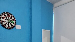 A room with a blue wall, a dartboard, and a mirror. - Casa Vazquez Anexo 1 (Pachuca)