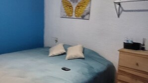 A bedroom with a bed, pillows, a dresser, and a wall art piece. - Casa Vazquez Anexo 1 (Pachuca)