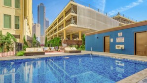 A swimming pool with lounge chairs and a view of a cityscape. - 3BR Downtown Dallas Loft | Fan Fest + Valet + Pool (Dallas)