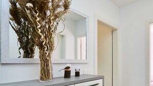Un baño moderno con encimera gris, muebles blancos y un espejo arriba.