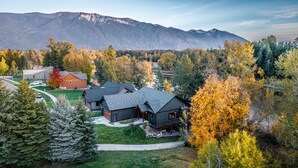 Ein Wohngebiet mit Häusern, umgeben von Herbstlaub und Bergen im Hintergrund.
