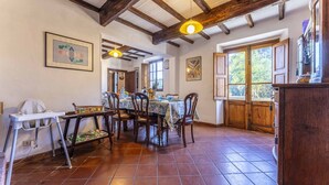 A dining area with a wooden table, chairs, and a high ceiling with exposed beams. - Vacation Home in Camaiore with 4 bedrooms sleeps 8 (Camaiore)