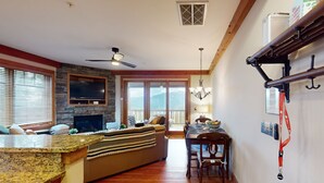 Un salon chaleureux avec une cheminée en pierre, une table à manger en bois et un canapé.