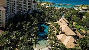 Un complexe hôtelier comprenant un grand bâtiment, une piscine et une vue sur l’océan.