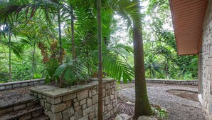 A stone staircase leading up to a building surrounded by lush greenery and a stone wall. - Two Bedroom Garden View Villa, Frenchman's Cove Resort (Drapers)