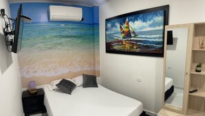 Un dormitorio con cama, mesita de noche, cómoda, un cuadro de un velero y un equipo de aire acondicionado.