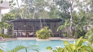 A pool area with a covered seating area, surrounded by lush greenery and trees. - Tú Refugio Exclusivo en Tulum Dk Jade 3 (Tulum)