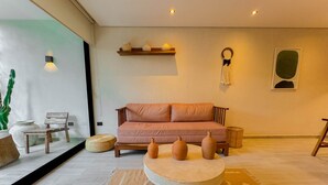 A modern living room with a sofa, a coffee table, and decorative items. - Tú Refugio Exclusivo en Tulum Dk Jade 3 (Tulum)