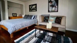 Une chambre à coucher avec un lit, un canapé, une table basse et une carte du monde accrochée au mur.