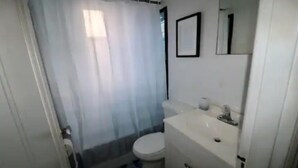 Une petite salle de bain avec des toilettes, un lavabo et un miroir.