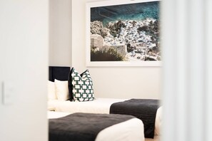 Ett hotellrum med en säng, en kudde och en inramad tavla på väggen.