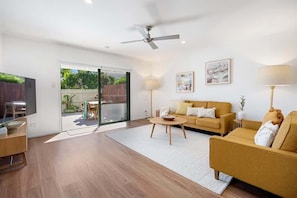 A modern living room with a sofa, coffee table, and a ceiling fan.