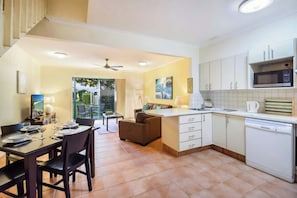 A compact kitchen with white cabinets, a microwave, and a dishwasher.