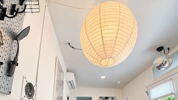A modern kitchen with a coffee maker, microwave, and a large pendant light.