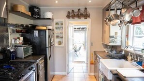Una cucina con forno, piano cottura, frigorifero e diversi utensili da cucina.