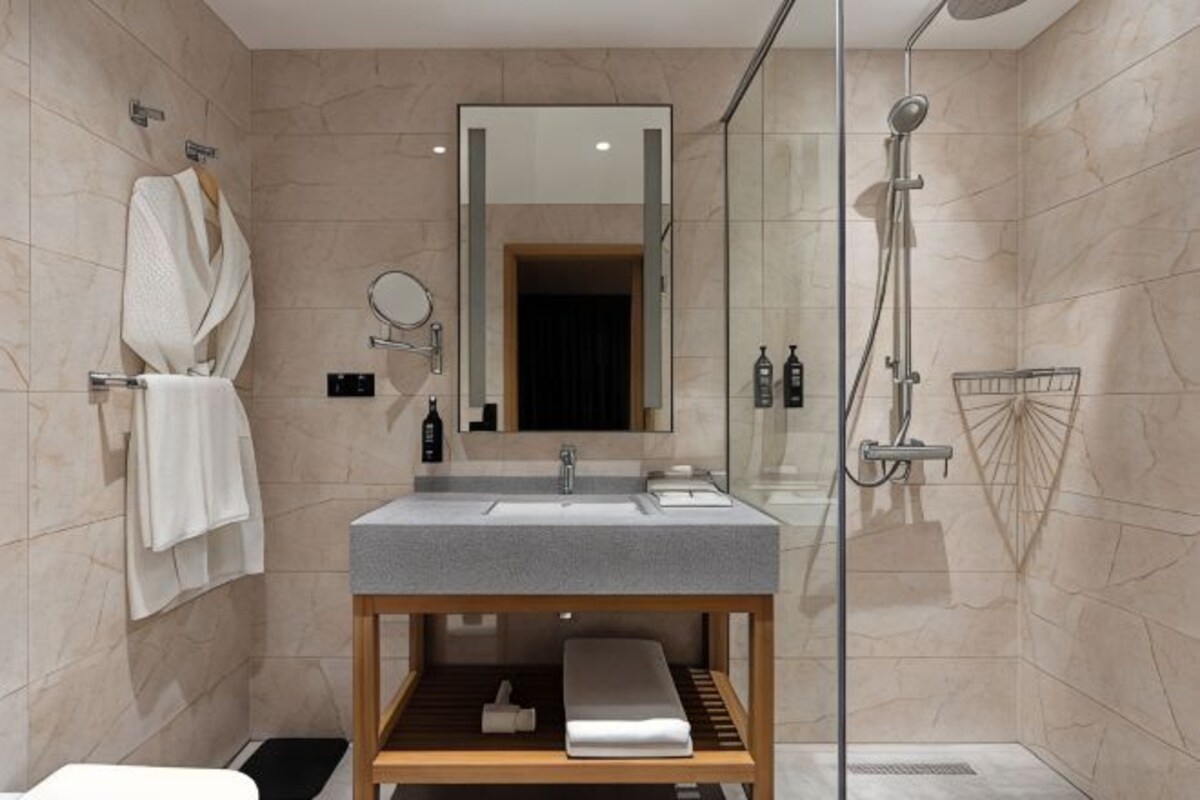 A modern bathroom with a glass shower enclosure, a wooden vanity with a sink, and a mirror.